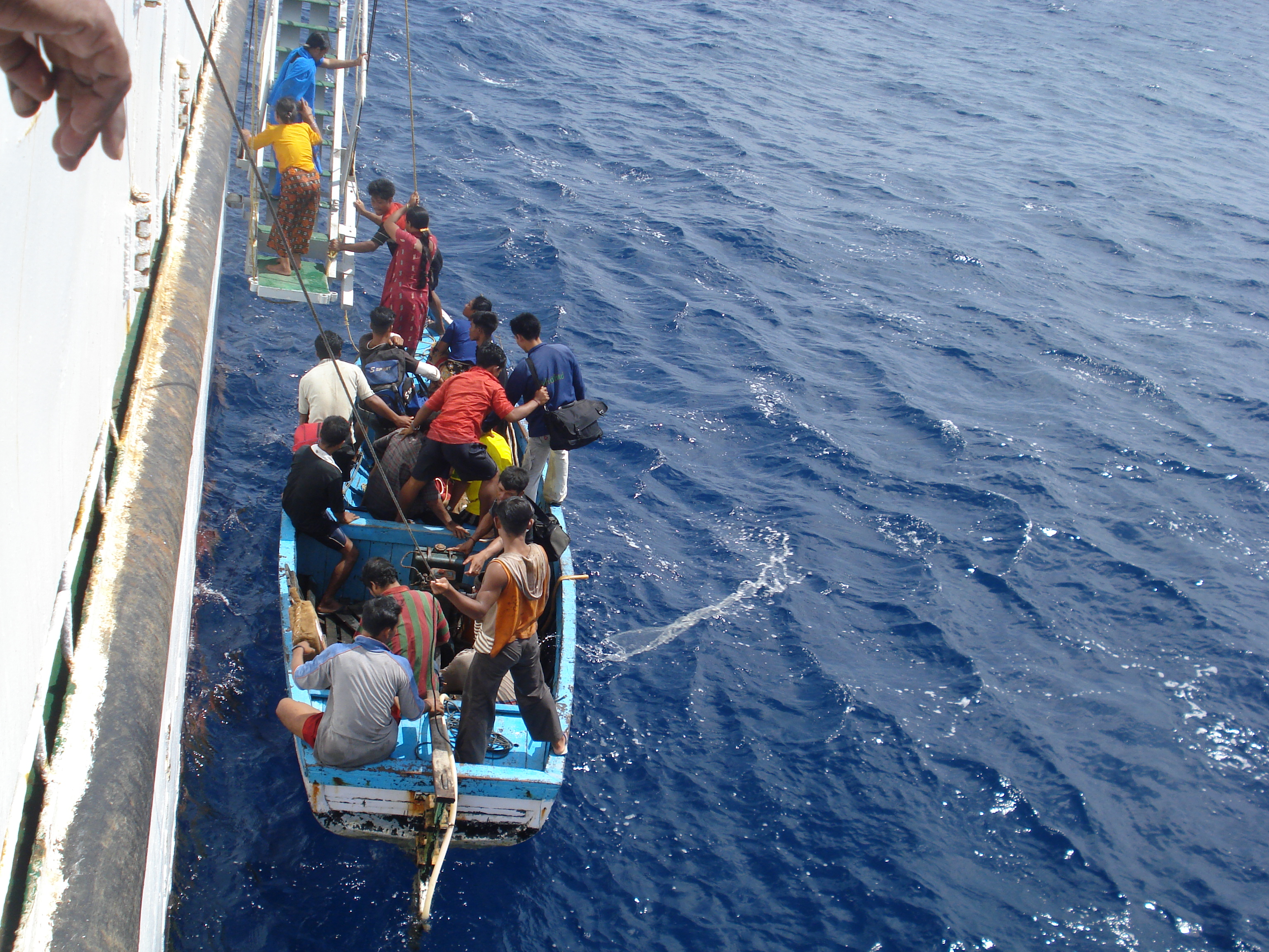 People boarding the ship from the canoe.JPG